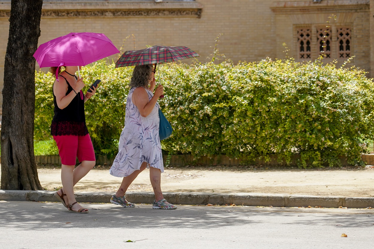 Dos mujeres con un paraguas pasean bajo el sol. Fuente: Europa Press.