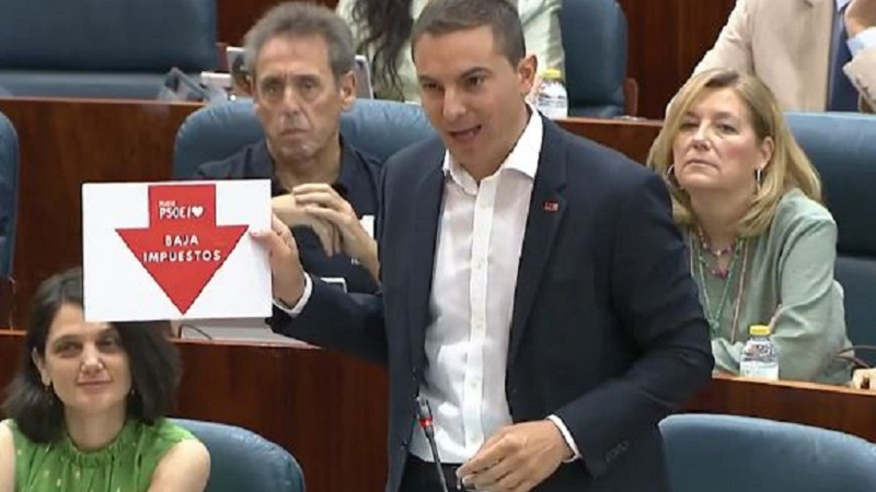 Cartel que le enseña Lobato a Ayuso en la Asamblea Cartel que le enseña Lobato a Ayuso en la Asamblea