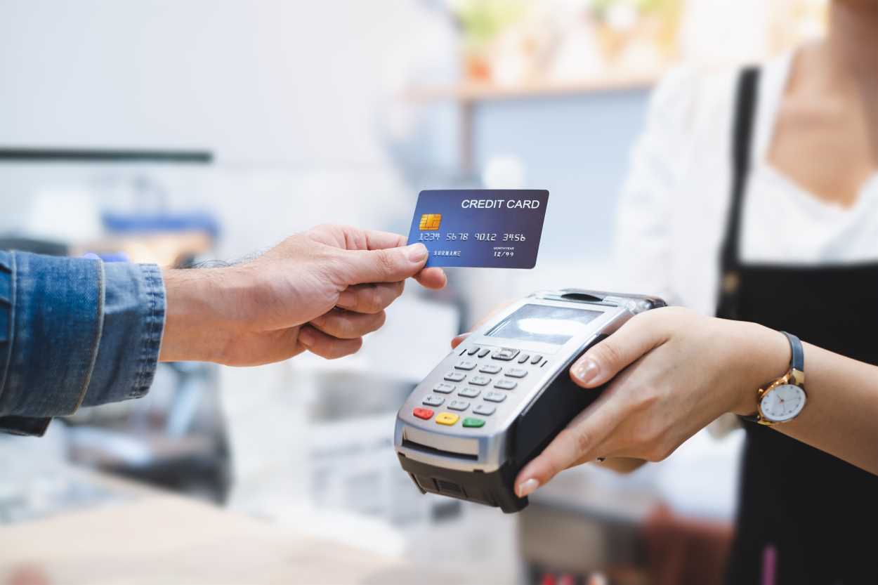 Una persona pagando con tarjeta de crédito en un datáfono. Archivo.