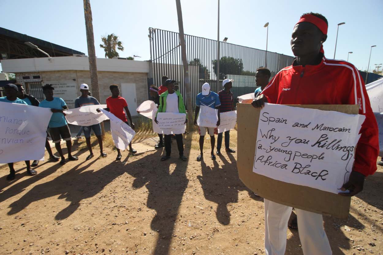 Un grupo de migrantes de origen subsahariano con carteles, durante una concentración en las inmediaciones del CETI para protestar por los hechos ocurridos el pasado 24 de junio en Melilla