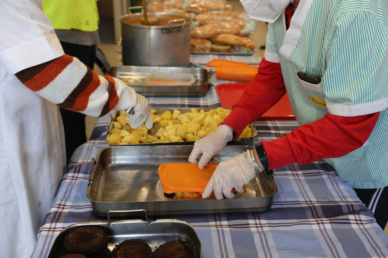 Una cocinera sirve comida en un comedor social. Europa Press
