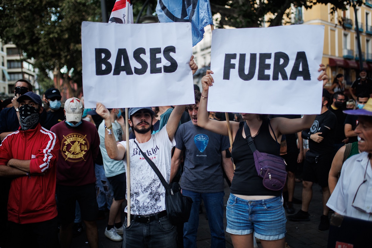 Varias personas sostienen pancartas durante una manifestación contra la Cumbre de la OTAN. EP.