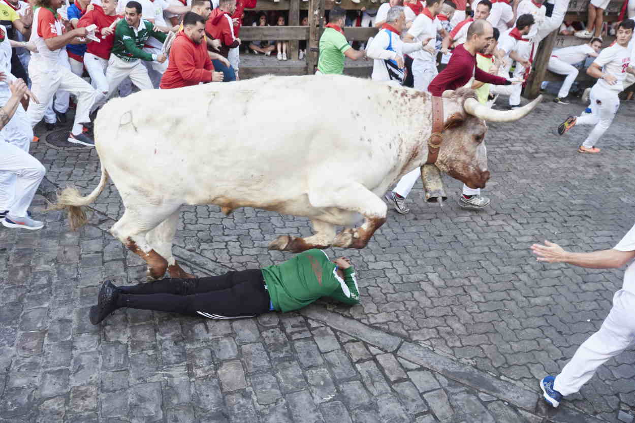 Un toro salta encima de un corredor durante el primer encierro de las Fiestas de San Fermín 2022 de la ganadería de Núñez de Cuvillo. EP.