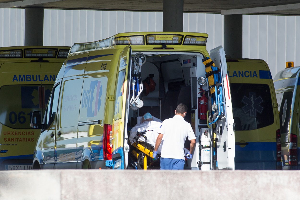 Un profesional sanitario baja de una ambulancia en camilla a un paciente con Covid 19 en Lugo-E.P