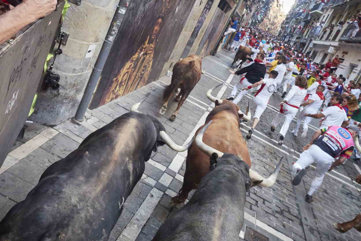 Corredores delante de los toro en el quinto encierro de los Sanfermines 2022. EP