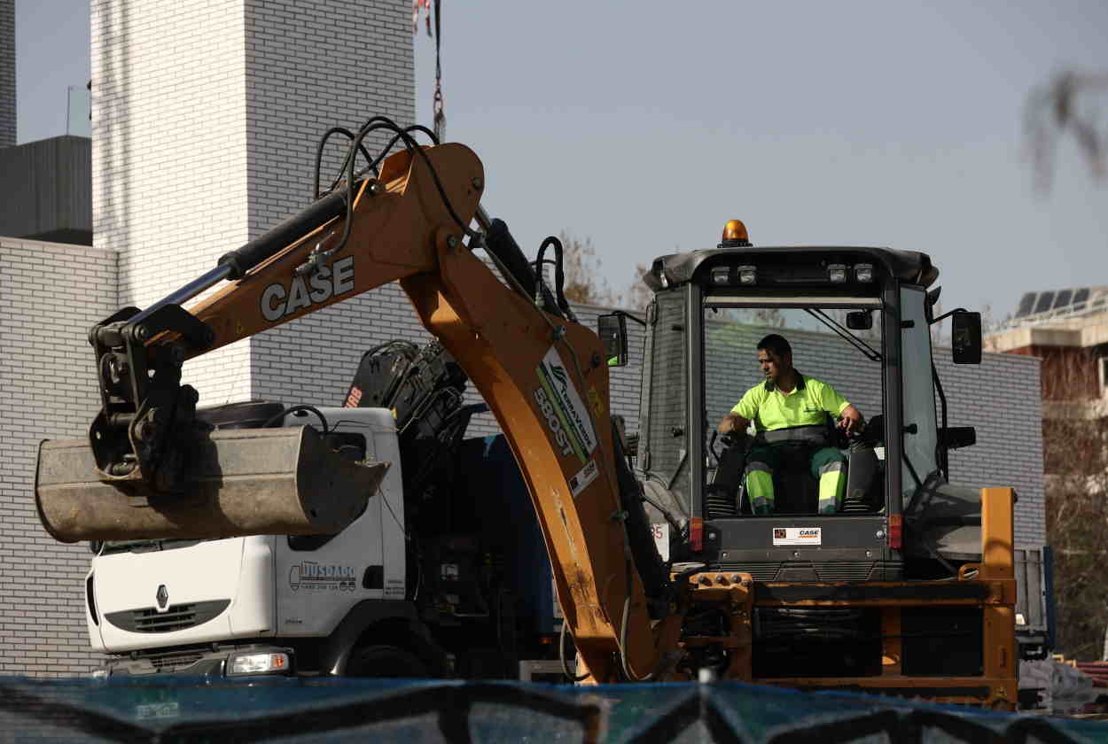 Trabajador de la construcción manejando una máquina escavadora. EP.