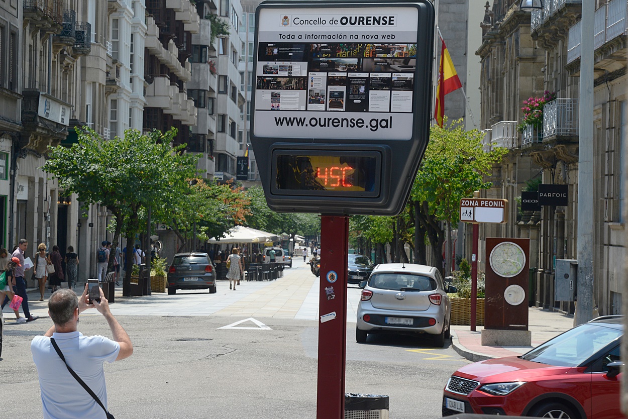 Imagen de un hombre haciendo una foto, esta semana, a un termómetro situado en una calle de Ourense capital (Foto: Europa Press).