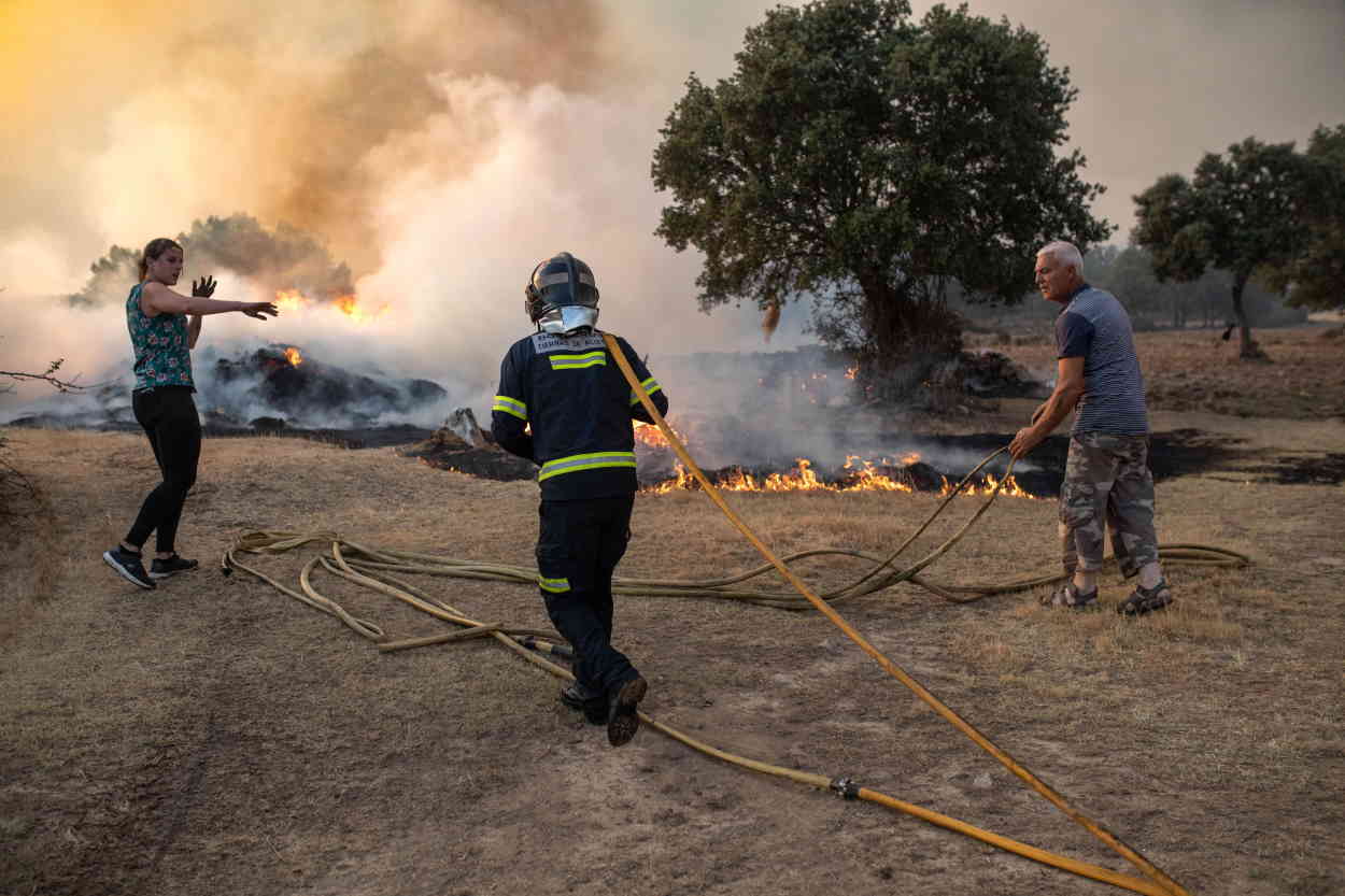 Un bombero y dos vecinos trabajan en la extinción del incendio de Losacio, a 17 de julio de 2022, en Losacio, Zamora, Castilla y León (España). EP