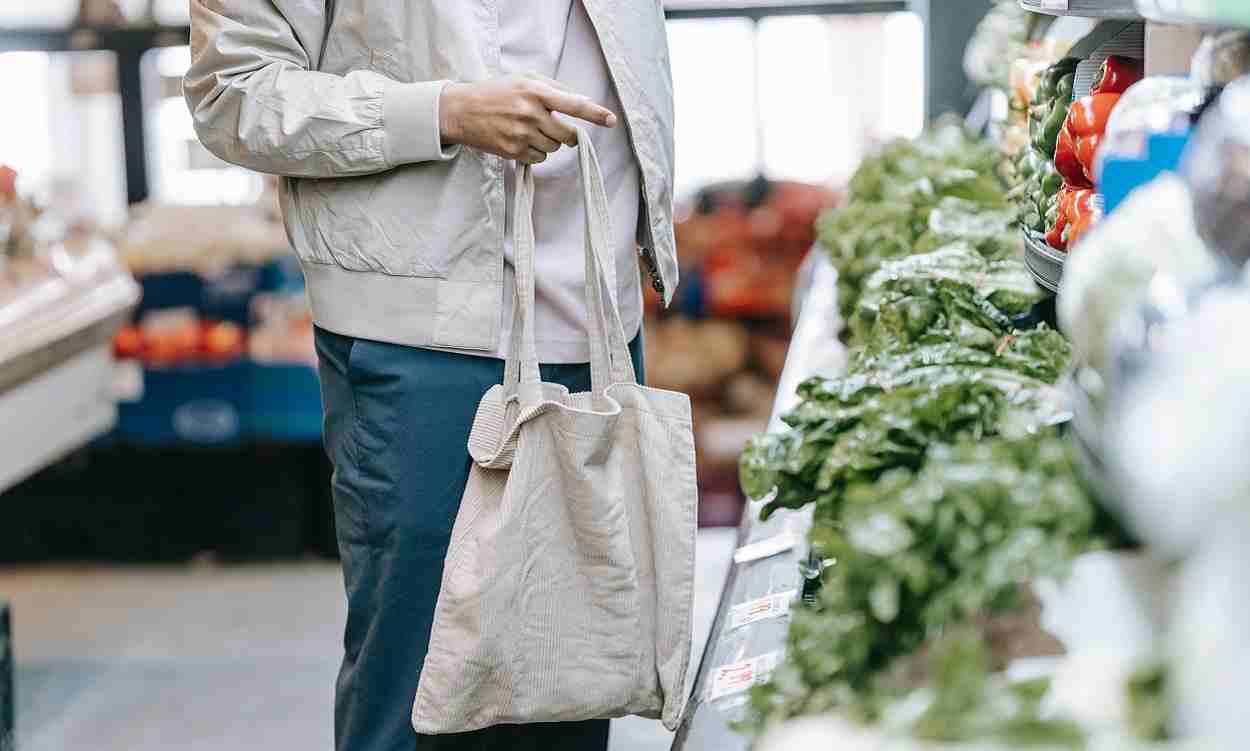 Una persona con una bolsa comprando en un supermercado. Pexels