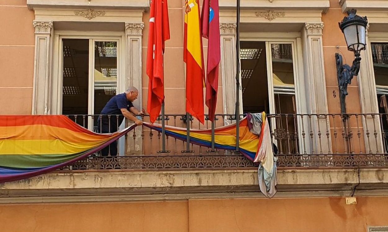 Un funcionario del Ayuntamiento de Madrid retira las banderas LGTBl de los balcones del edificio de grupos municipales
