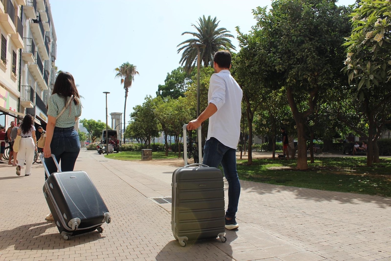 Dos turistas en Málaga capital con sus maletas
