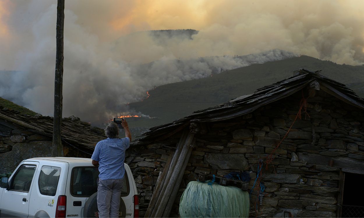 Un hombre fotografía las llamas del incendio de Laza (Ourense, Galicia). EP.