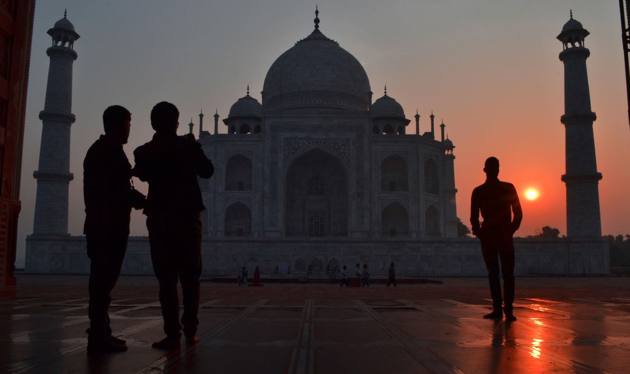 Personas observan el amanecer en el mausoleo de Taj Mahal. EP
