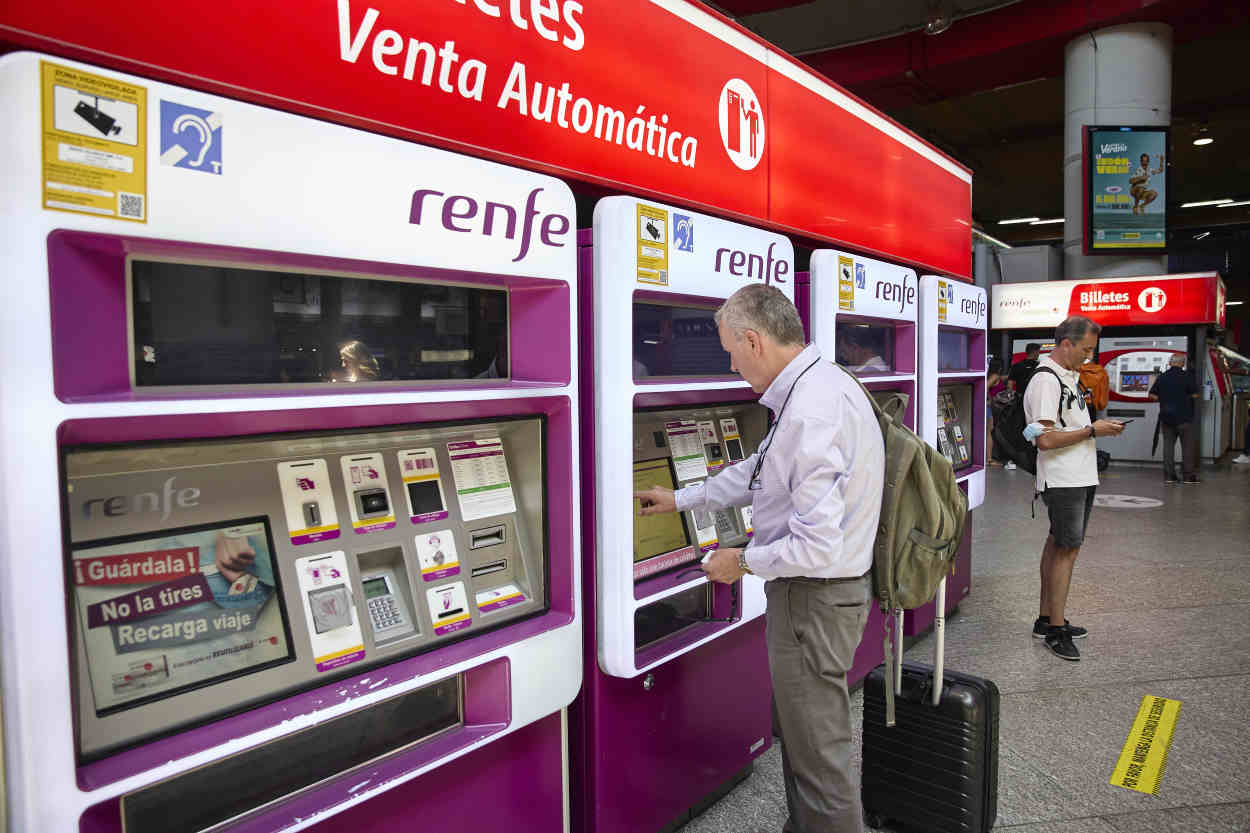 Una persona en una de las máquinas de venta de billetes en la estación Madrid Atocha Cercanías. Europa Press