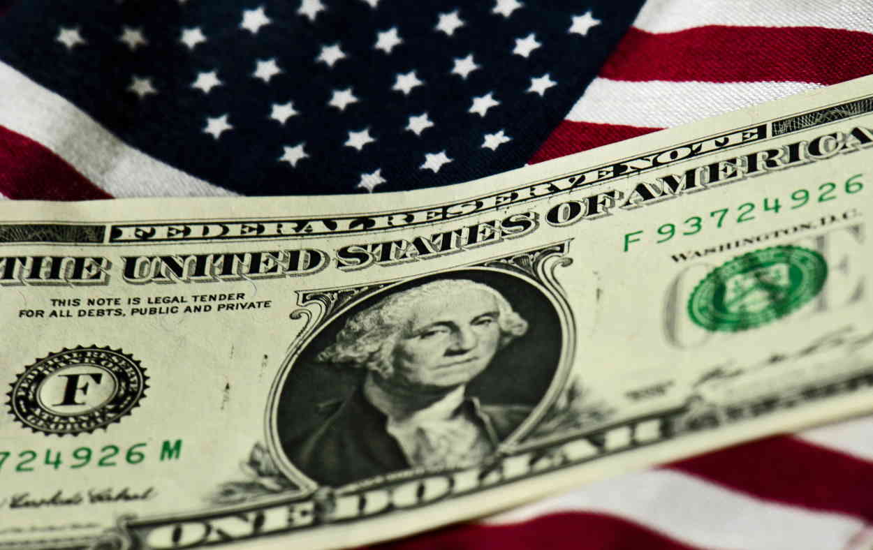 Billete de un dólar sobre la bandera de los Estados Unidos. Europa Press