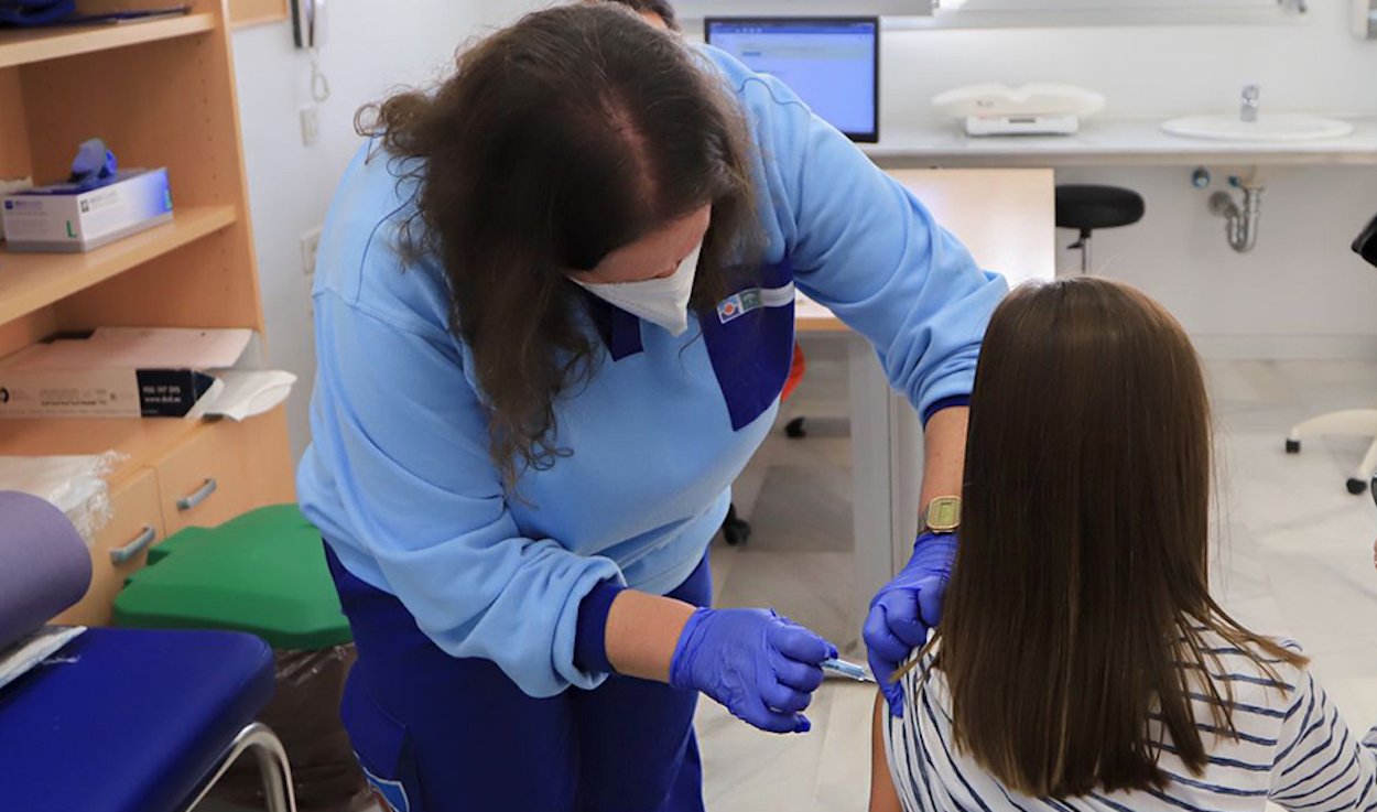 Una profesional del Servicio Andaluz de Salud dispensa una vacuna a una menor.