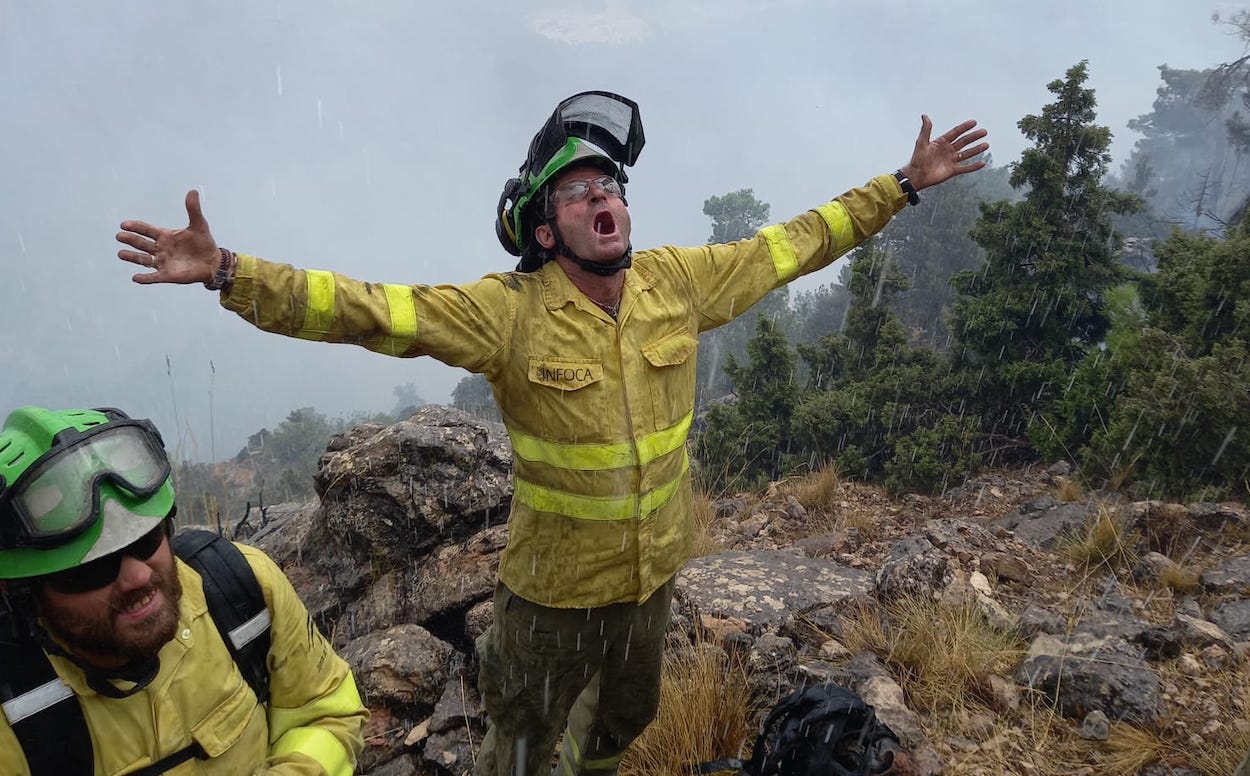 Así recibía ayer un bombero del Infoca la lluvia caída en la zona del incendio. INFOCA