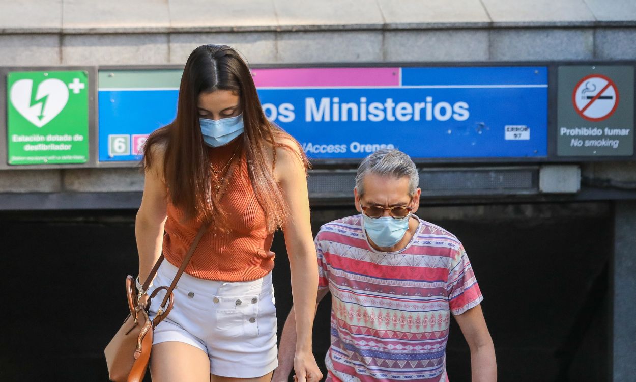 Dos transeúntes con mascarilla en el Metro de Madrid. EP.