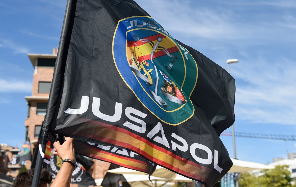 Una bandera con el emblema de Jusapol durante una manifestación. EP