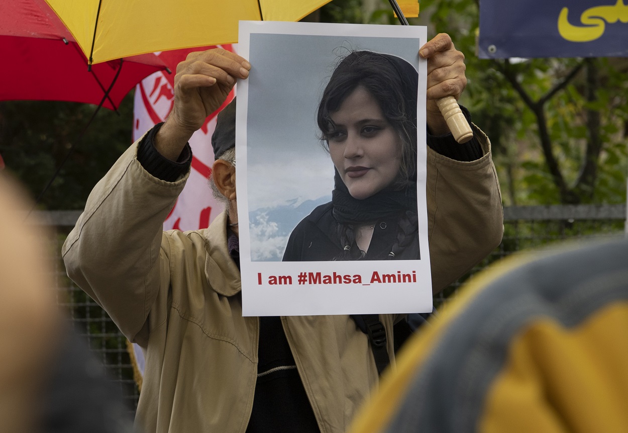 Un hombre sostiene un cartel con la imagen de Mahsa Amini, durante las protestas. EP.