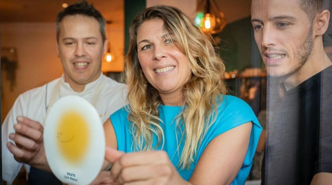 María Ritter junto a Alex y Adrián de La Fuente poniendo la pegatina del Solete de Barrio en InPulso