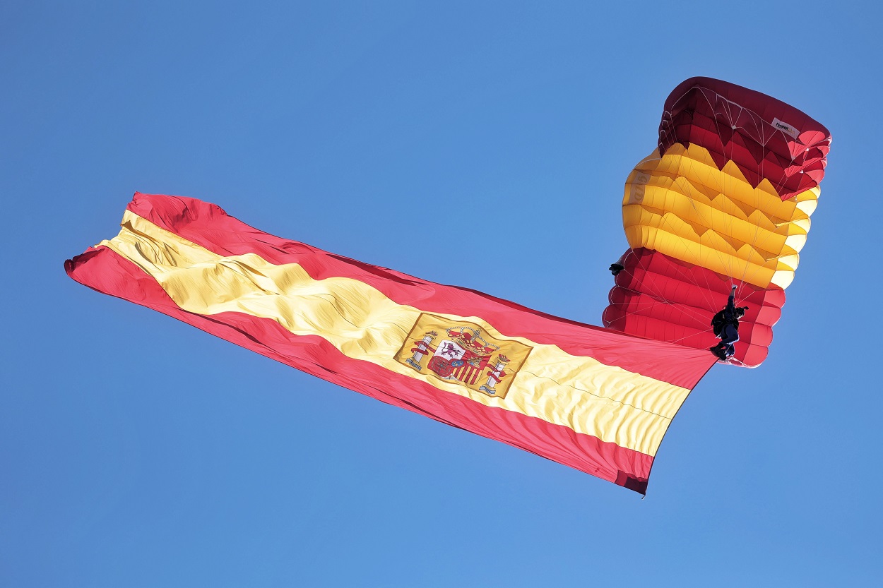 Un paracaidista carga con la bandera de España durante acto solemne de homenaje a la bandera nacional y desfile militar en el Día de la Hispanidad, a 12 de octubre de 2021. EP.