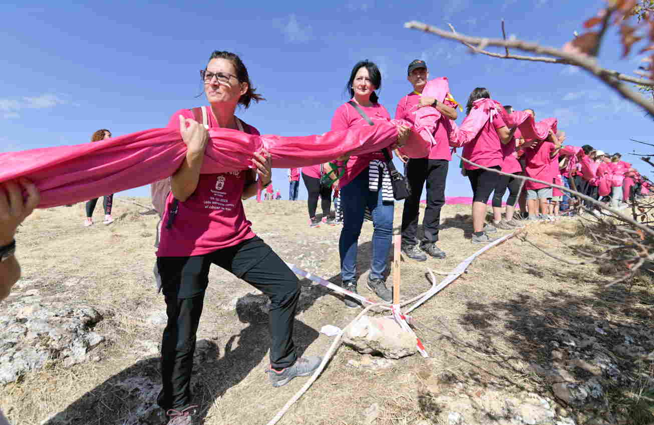 Voluntarios colocan un lazo rosa confeccionado con 5.720 metros cuadrados de tela en la cima de Las Tetas de Viana para luchar contra el Cáncer de Mama. Europa Press