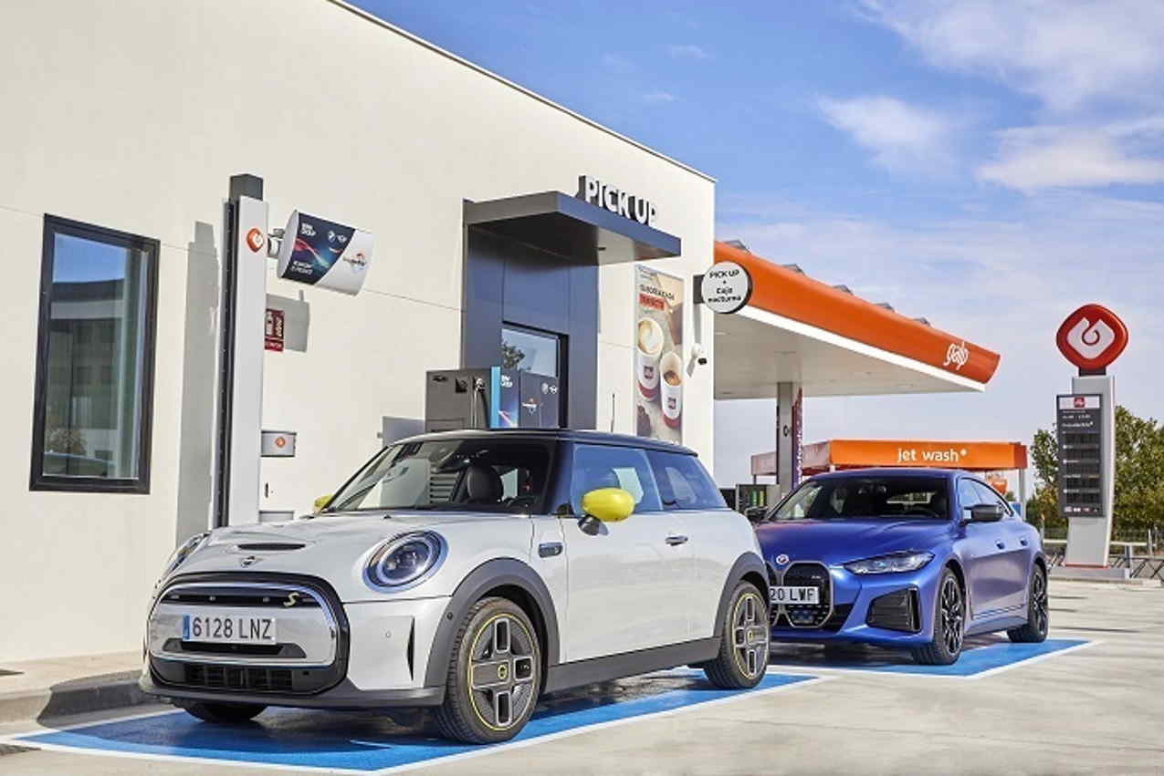 Coches eléctricos en un puesto de recarga junto a una estación de servicio. Europa Press