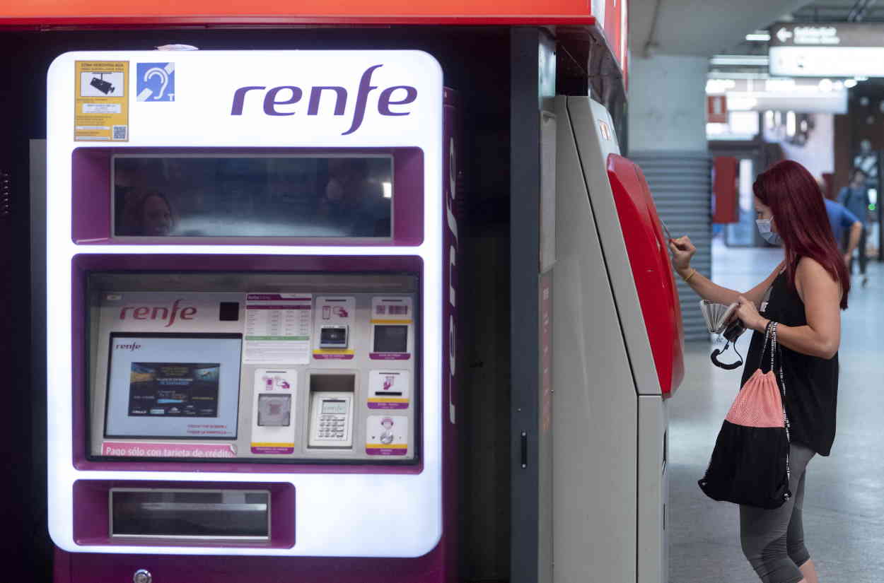 Una mujer compra su billete en las taquillas de venta automática de la estación de tren de Atocha. EP