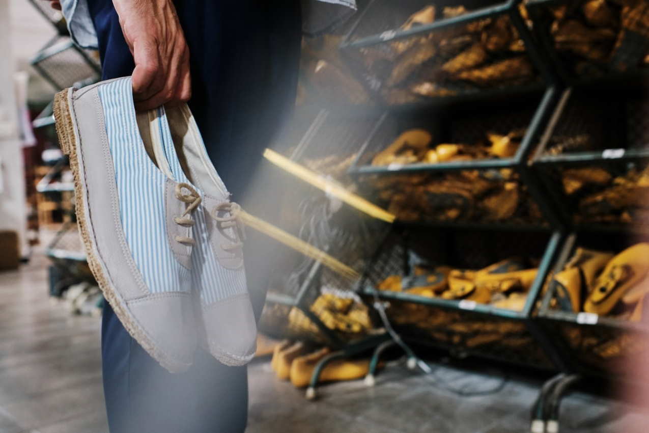 Un hombre sostiene unos zapatos frente a una tienda de calzado. Europa Press