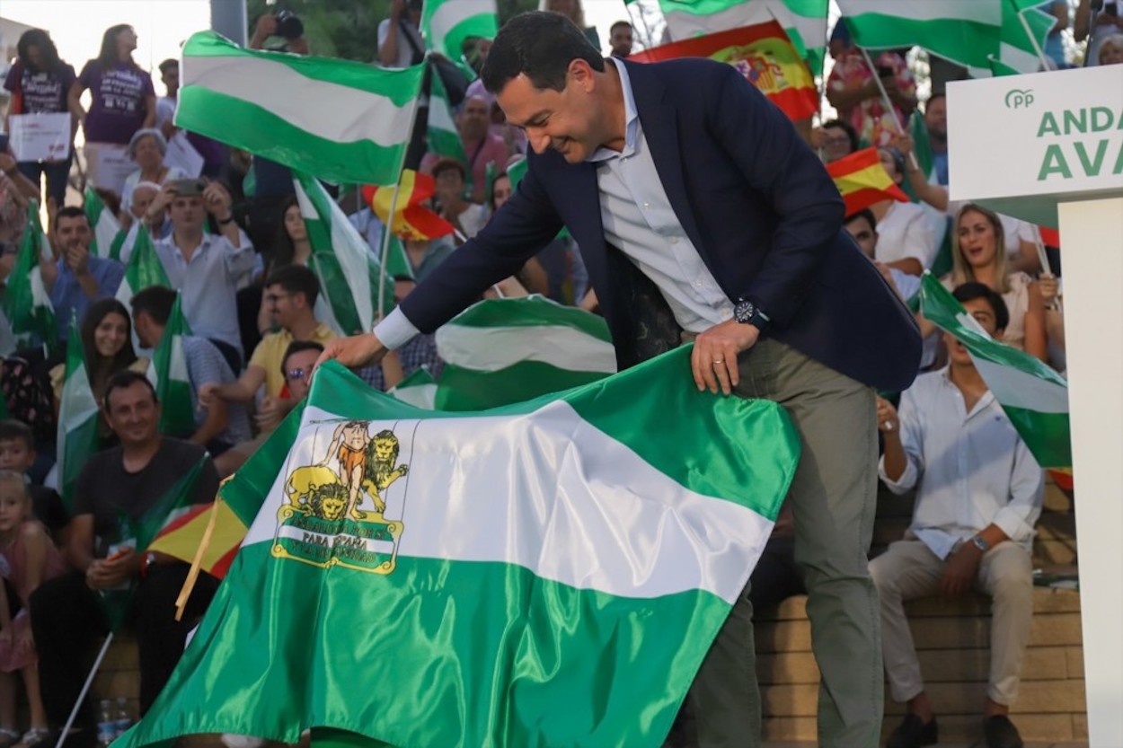 Juan Manuel Moreno, con la bandera andaluza durante la campaña electoral de junio pasado. ÁLEX ZEA/EP