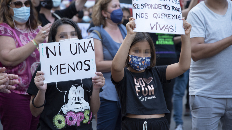 Dos niñas sujetan una pancarta contra la violencia de género