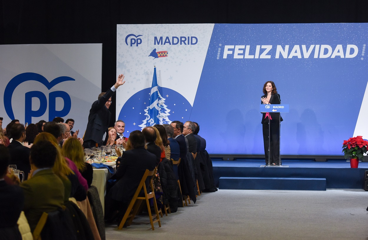 Imagen de la cena navideña del PP de Madrid. Ayuso, en el escenario, aplaude a Feijóo cuando saluda a los presentes. EP
