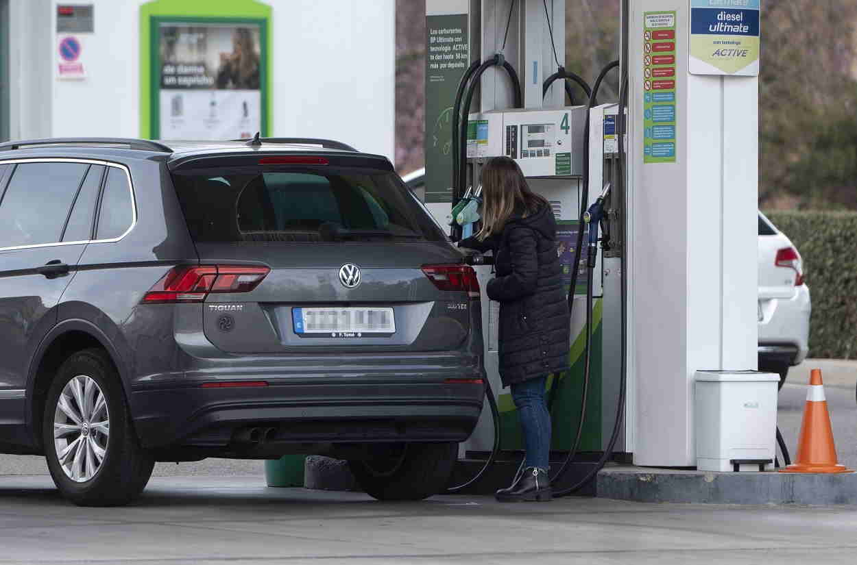 Una mujer reposta combustible en una gasolinera. EP
