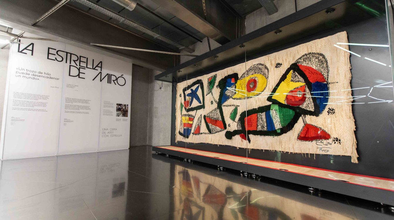 La estrella de Miró muestra el tapiz a los visitantes que llegan y se van del centro acompañado de plafones que cuentan la historia de la pieza