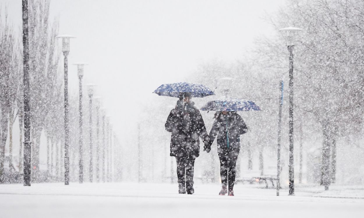 Una pareja camina bajo la nieve, a 18 de enero de 2023, en Pamplona, Navarra (España). EP.