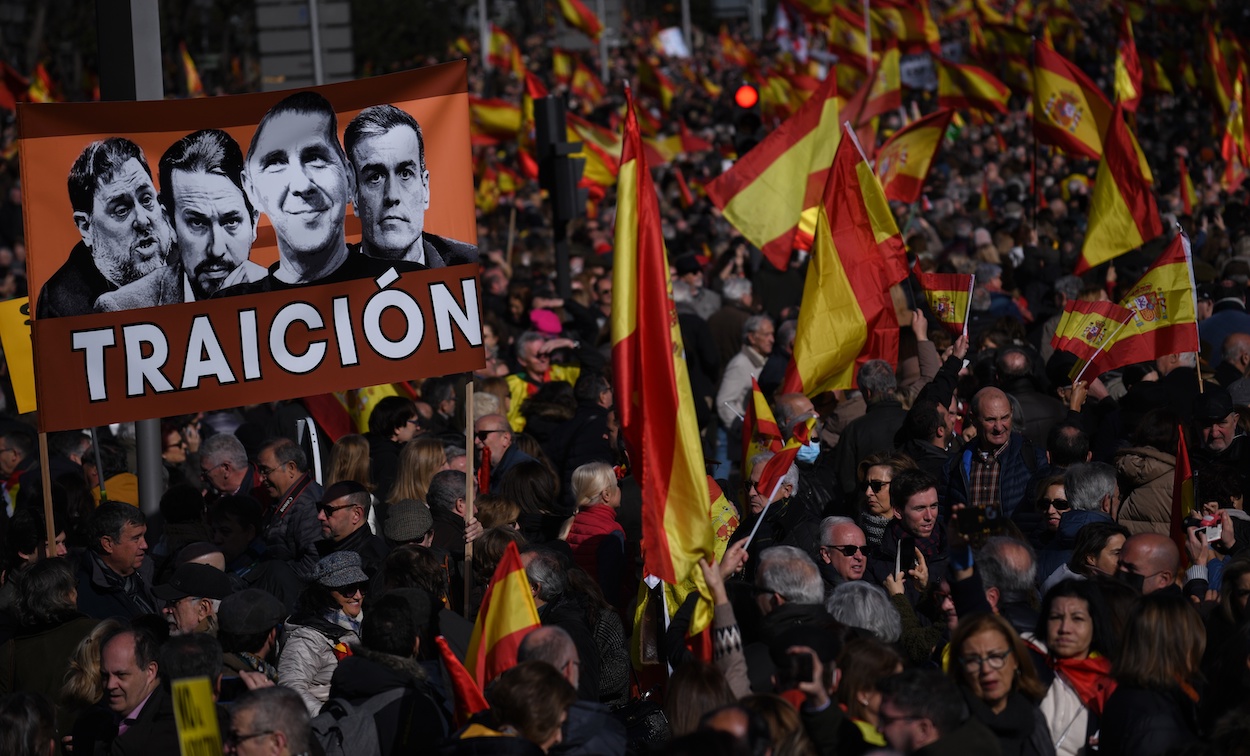 Varias personas sostienen un cartel de 'Traición' en la manifestación contra el Gobierno de Pedro Sánchez, ayer en Madrid. FERNANDO SÁNCHEZ/EP