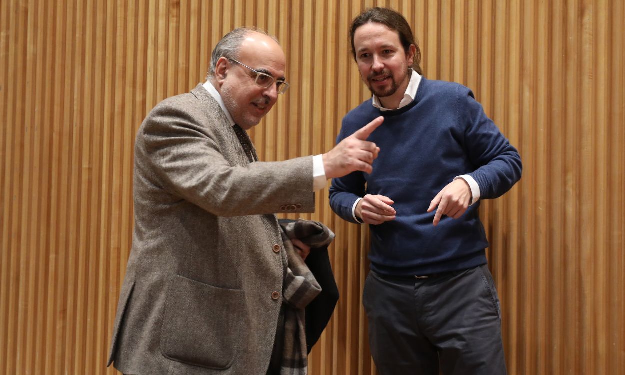 El periodista Enric Juliana (i) y el secretario general de Podemos, Pablo Iglesias (d) a su llegada al diálogo `Nudo España un año después´ en el Congreso de los Diputados, en Madrid (España), a 5 de diciembre de 2