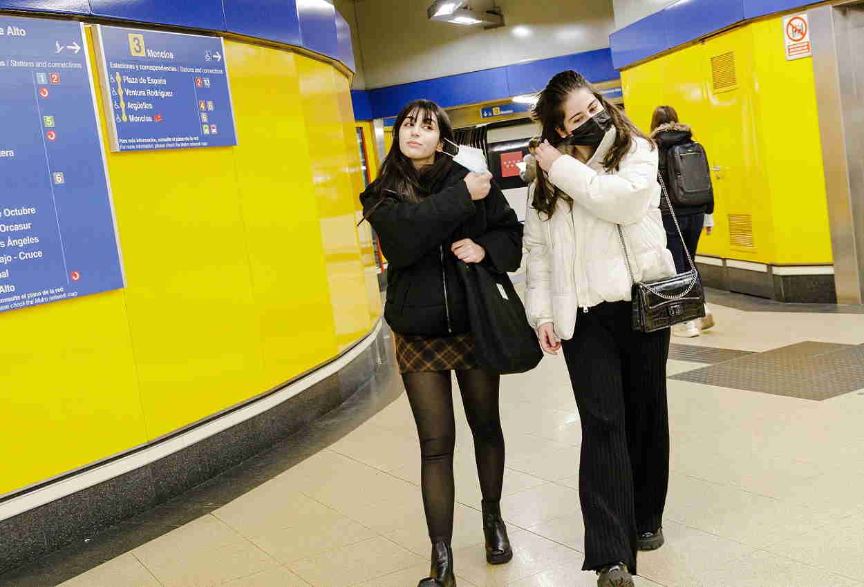 Dos jóvenes se quitan la mascarilla en el andén del Metro de Madrid. EP