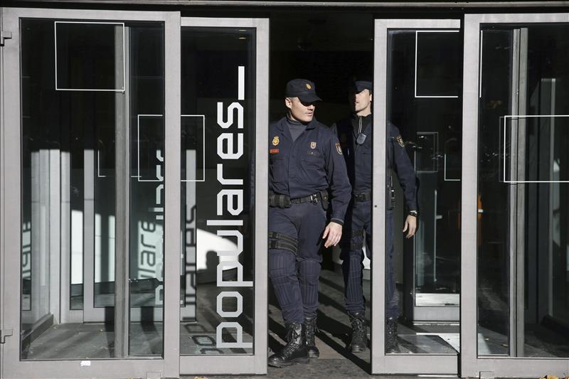 Policías salen de la sede del PP, en la madrileña calle Génova