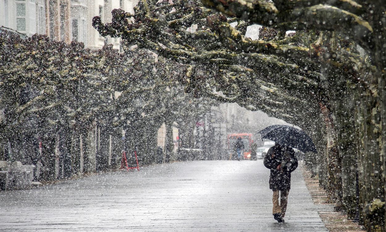 Una persona camina bajo la nieve por las calles de Burgos, Castilla y León. EP.