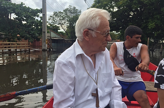 El padre Ángel en una barca comprobando el desastre de las inundaciones en Paraguay.