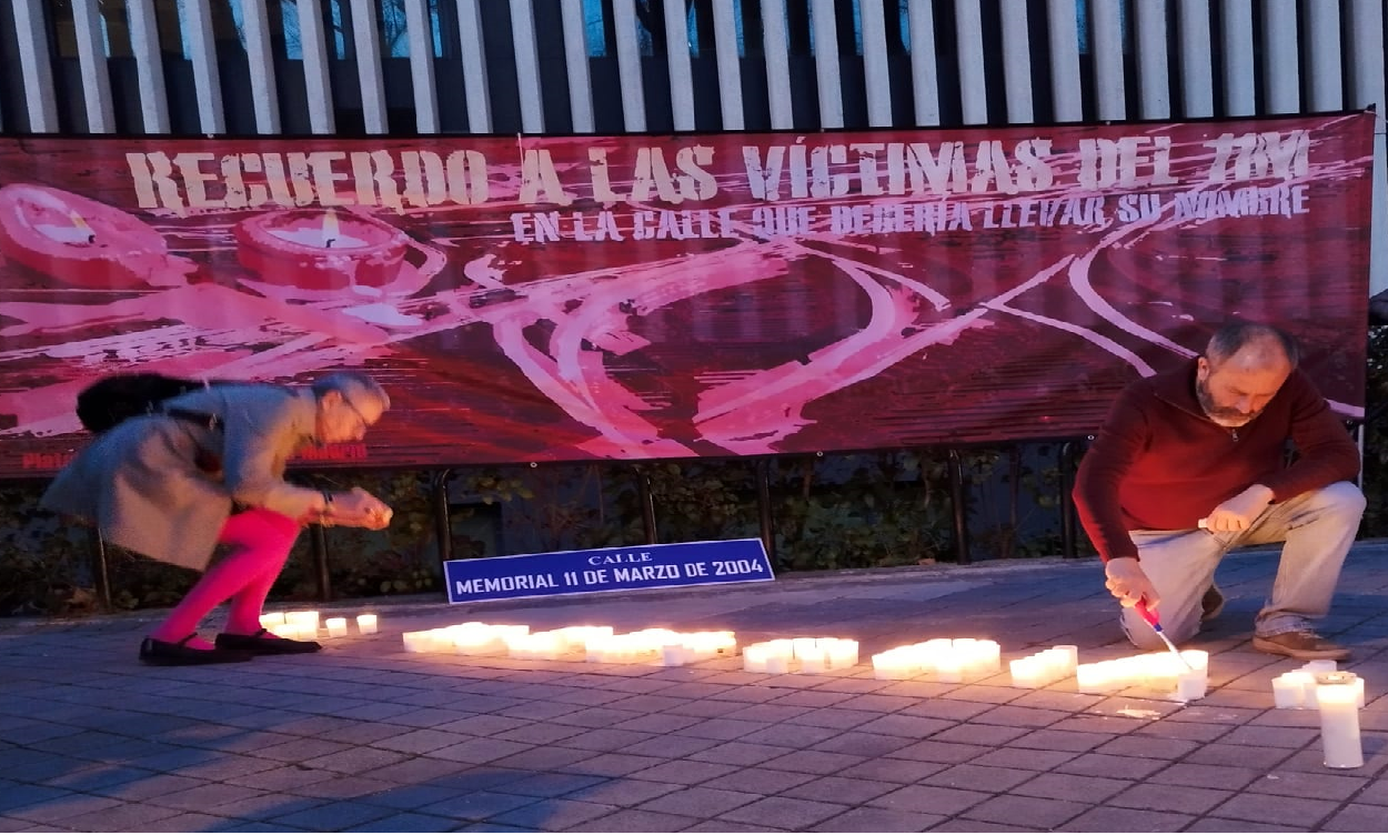 Imagen de varias personas encendiendo las velas del homenaje a las víctimas del 11M