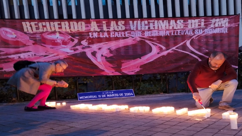 Imagen de varias personas encendiendo las velas del homenaje a las víctimas del 11M