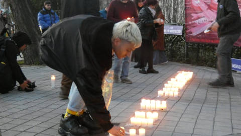 Imagen de un joven encendiendo una vela en el acto