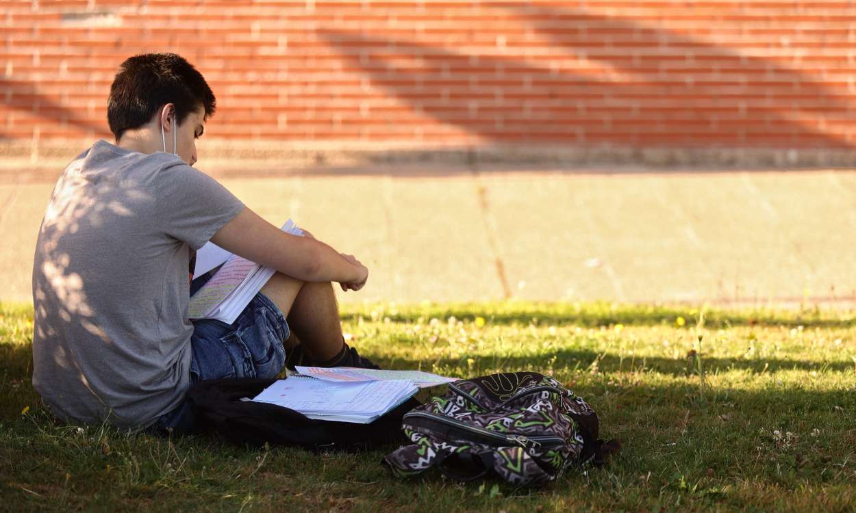 Un estudiante repasa sus apuntes antes de comenzar uno de los exámenes de la EvAU en la Universidad Complutense. EP