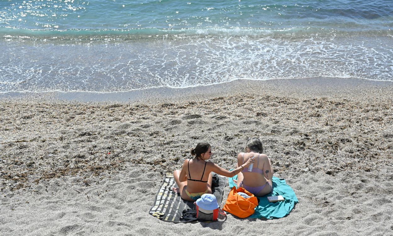 Unas chicas toman el sol en bañador junto al mar aprovechando las altas temperaturas, Murcia. EP