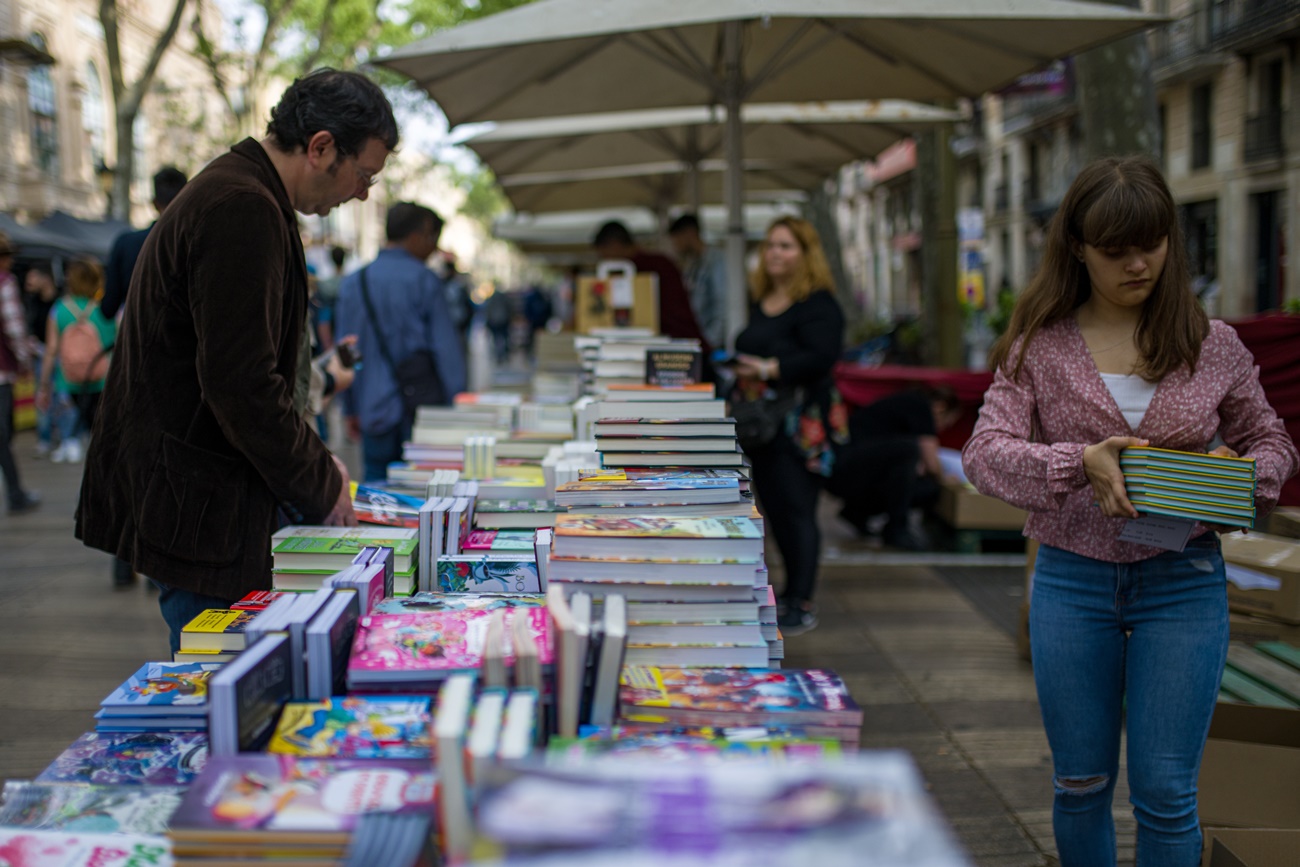 Un hombre busca libros en un puesto en la calle durante la celebración del Día Internacional del Libro