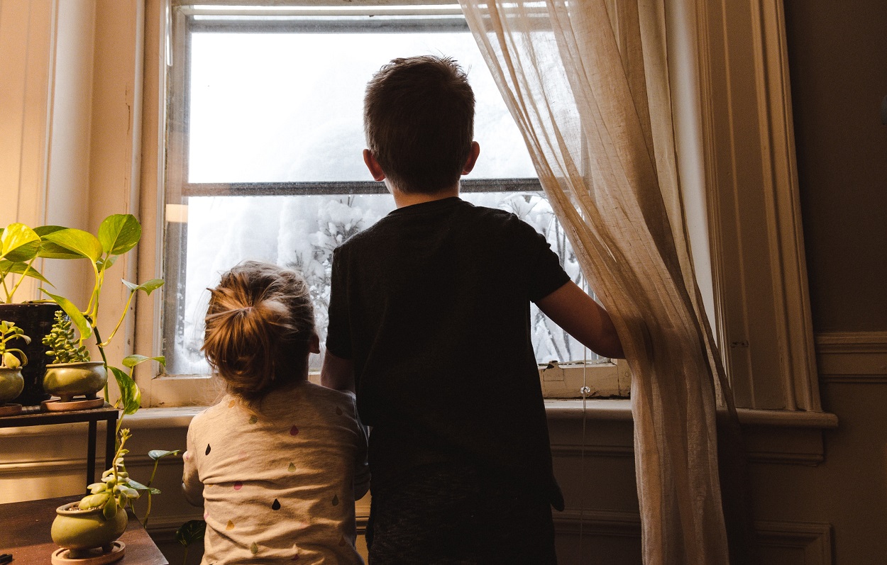 Imagen de dos niños mirando por la ventana. Kelly Sikkema