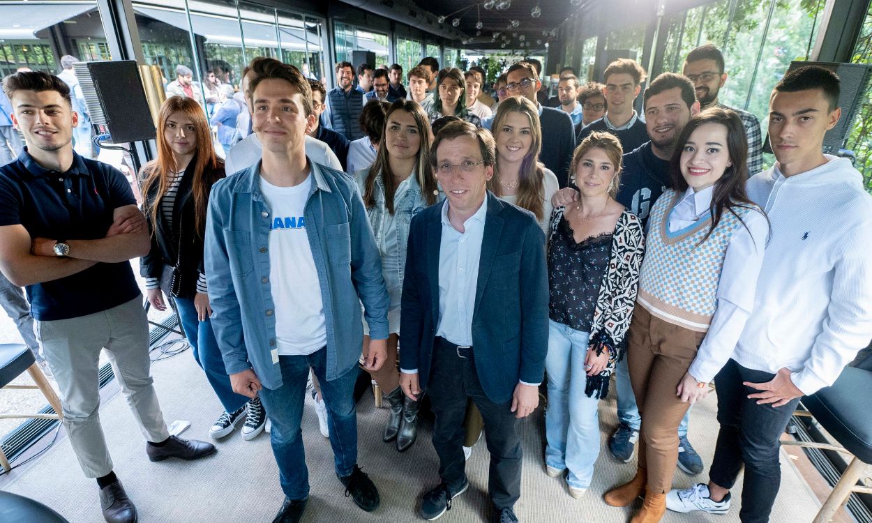 El presidente de Nuevas Generaciones del PP de Madrid, Ignacio Dancausa (i) y el alcalde de Madrid y candidato del PP a la reelección, José Luis Martínez Almeida (d), posan junto a algunos miembros de Nuevas Genera